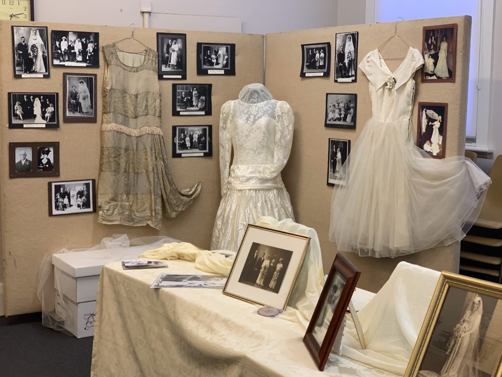 Display of wedding photos and three wedding dresses